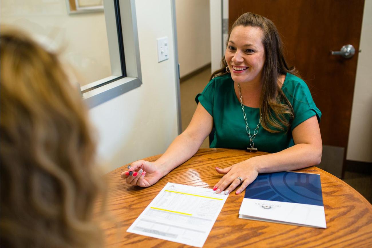 Woman helping girl fill out application