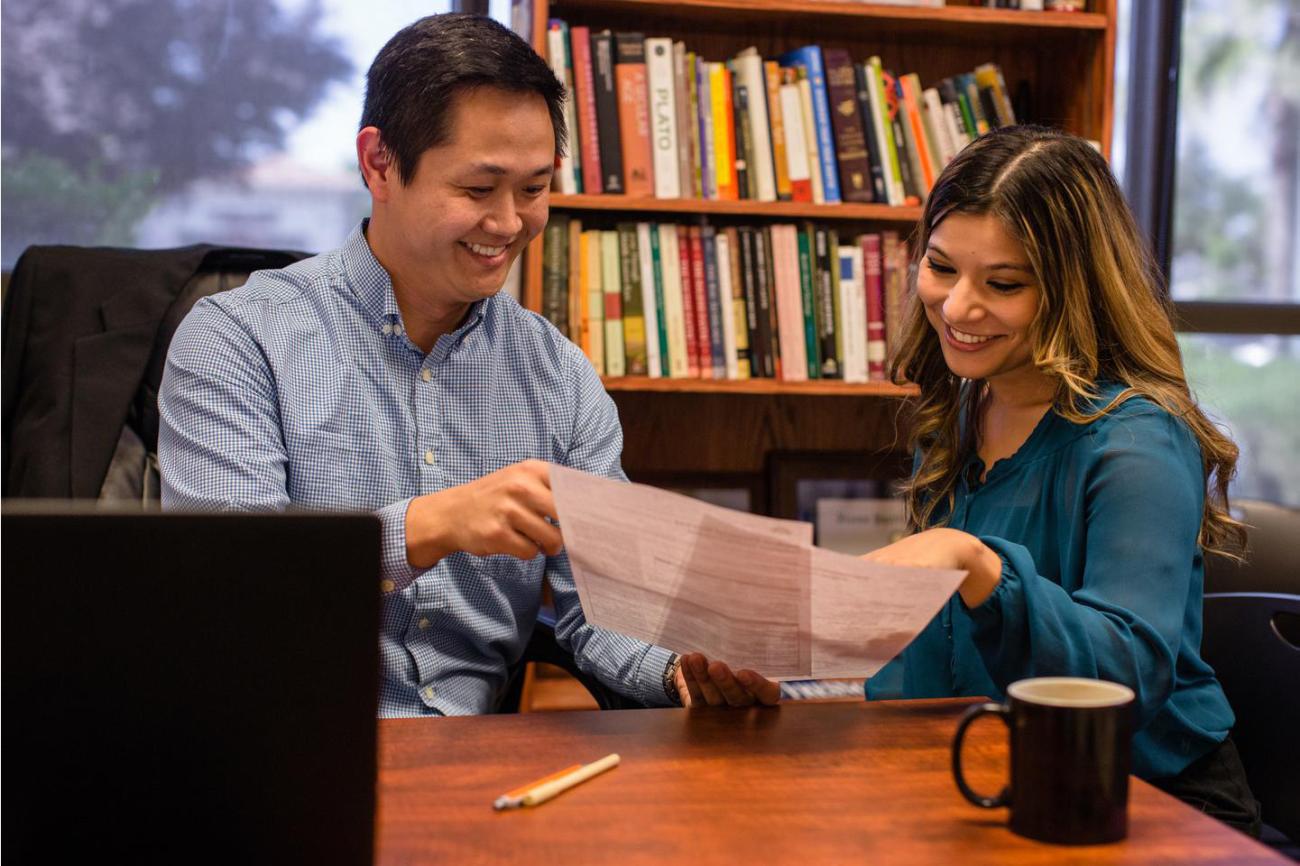 Photo of a student talking with an adult.