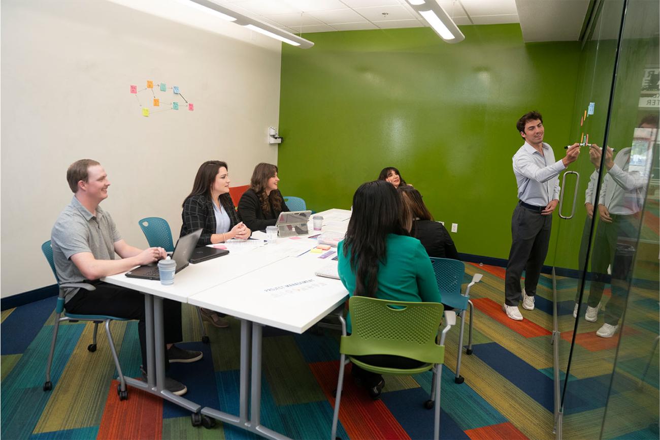 Photo of students sitting around a table in a classroom