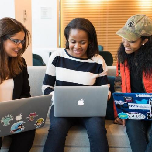 Three students looking at laptops