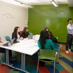 Photo of students sitting around a table in a classroom